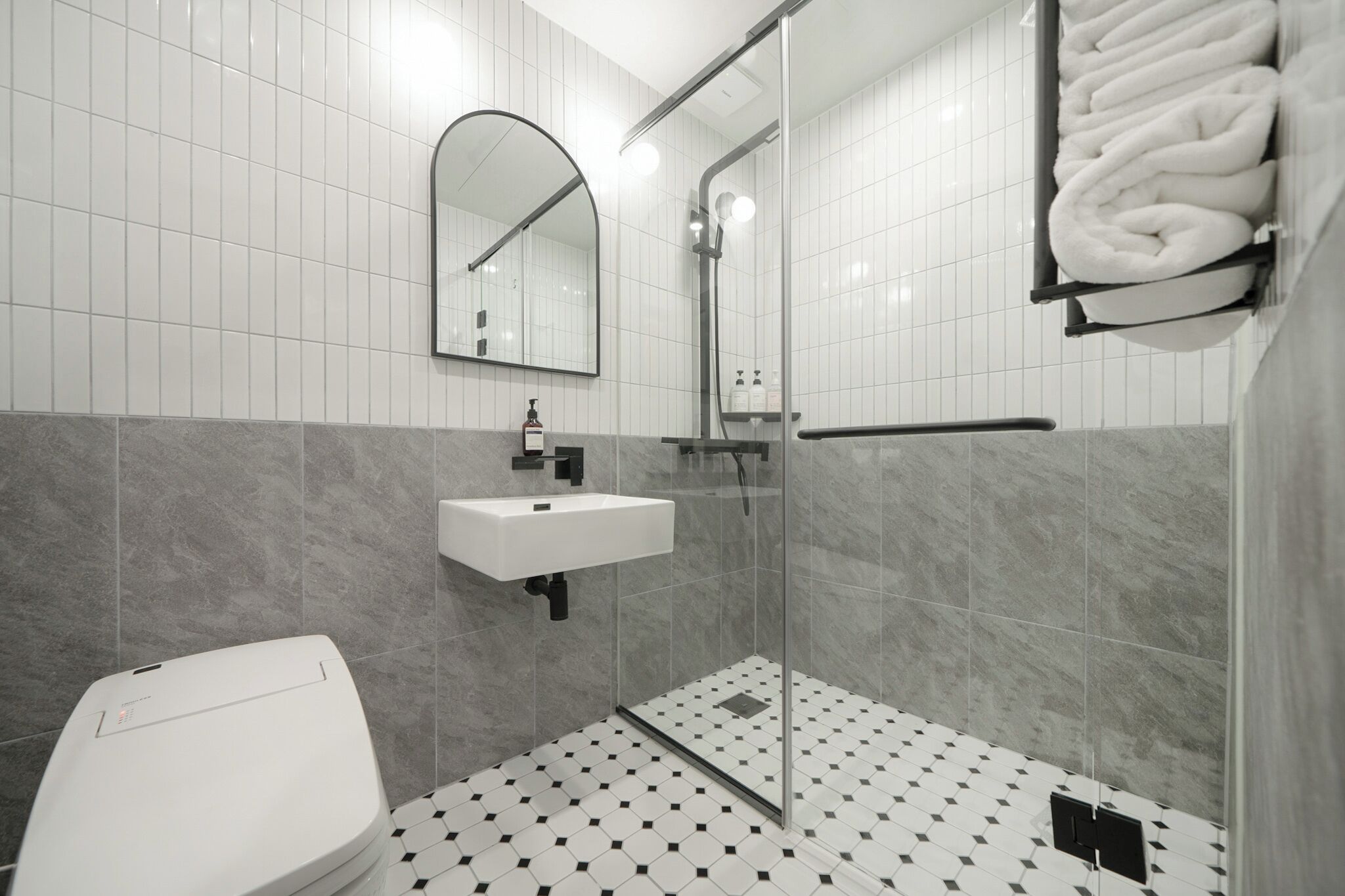 Ein modernes Badezimmer mit Toilette, Waschbecken und einer Duschkabine.