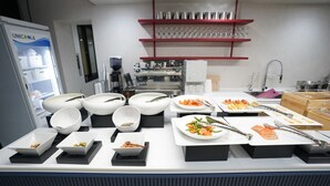 A buffet setup with various dishes and utensils.