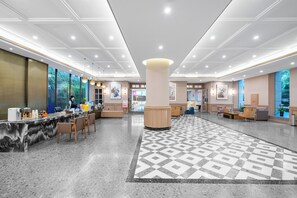A spacious lobby with a marble reception desk, comfortable seating areas, and large windows offering views of greenery. - shuaifubosongfandian (Wuhan)
