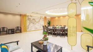 A modern hotel lobby with a marble reception desk, a dining area with round tables, and a seating area with sofas and chairs. - shuaifubosongfandian (Wuhan)