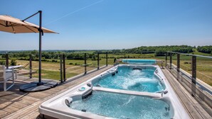 A hot tub on a wooden deck with a view of a green landscape. - Rèverie en Périgord du Domaine des Hauts de Rouquette (Eymet)