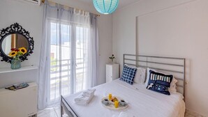A neatly arranged bedroom with a bed, bedside table, and a window with curtains. - Alisahni Home 1, Villa (Chania)
