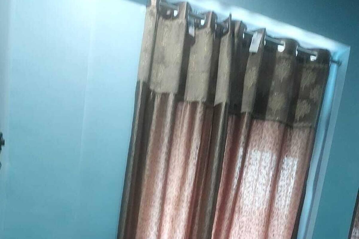 A room with a bed, a pillow, and curtains.