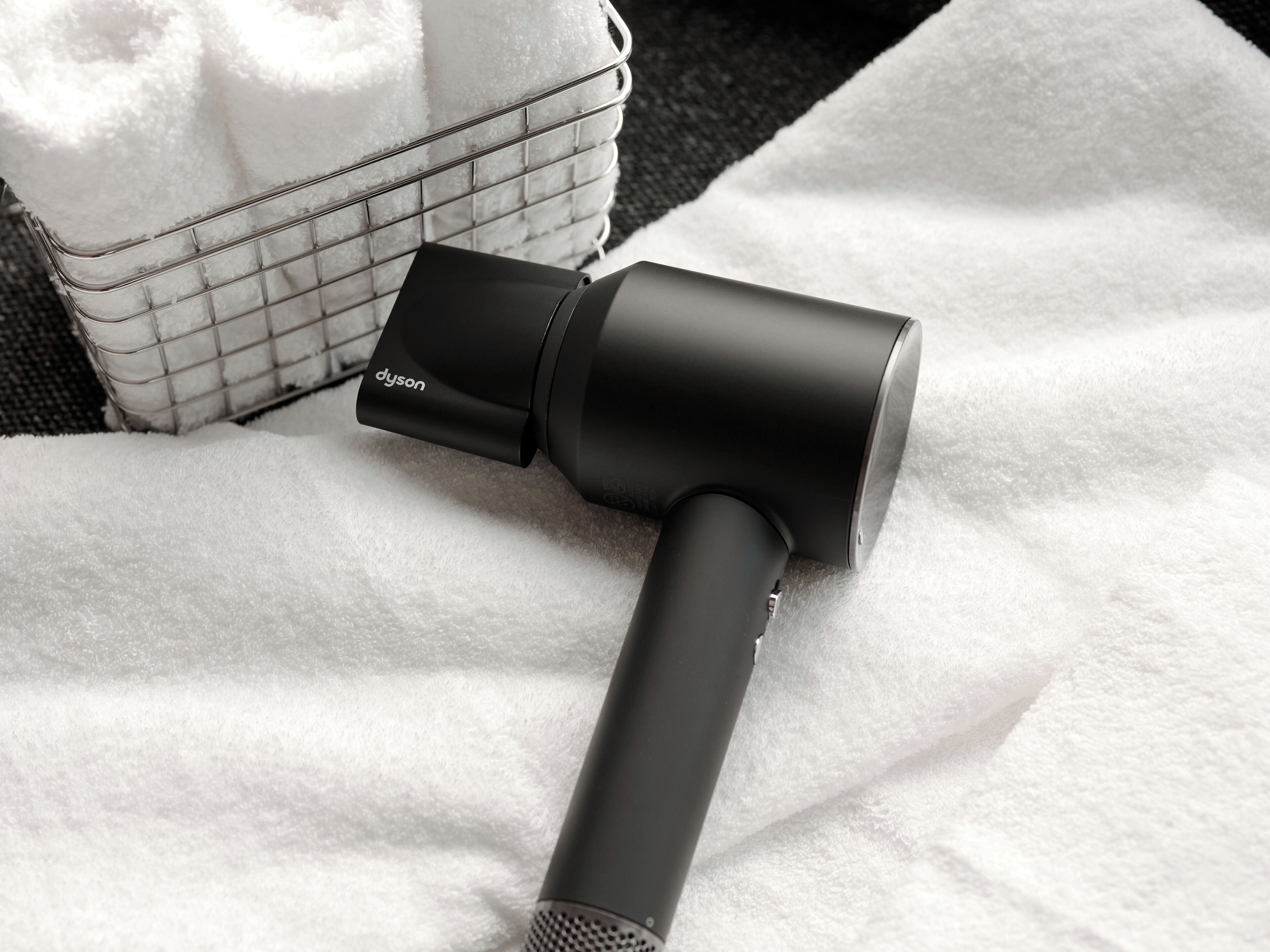 A Dyson hair dryer on a white towel.