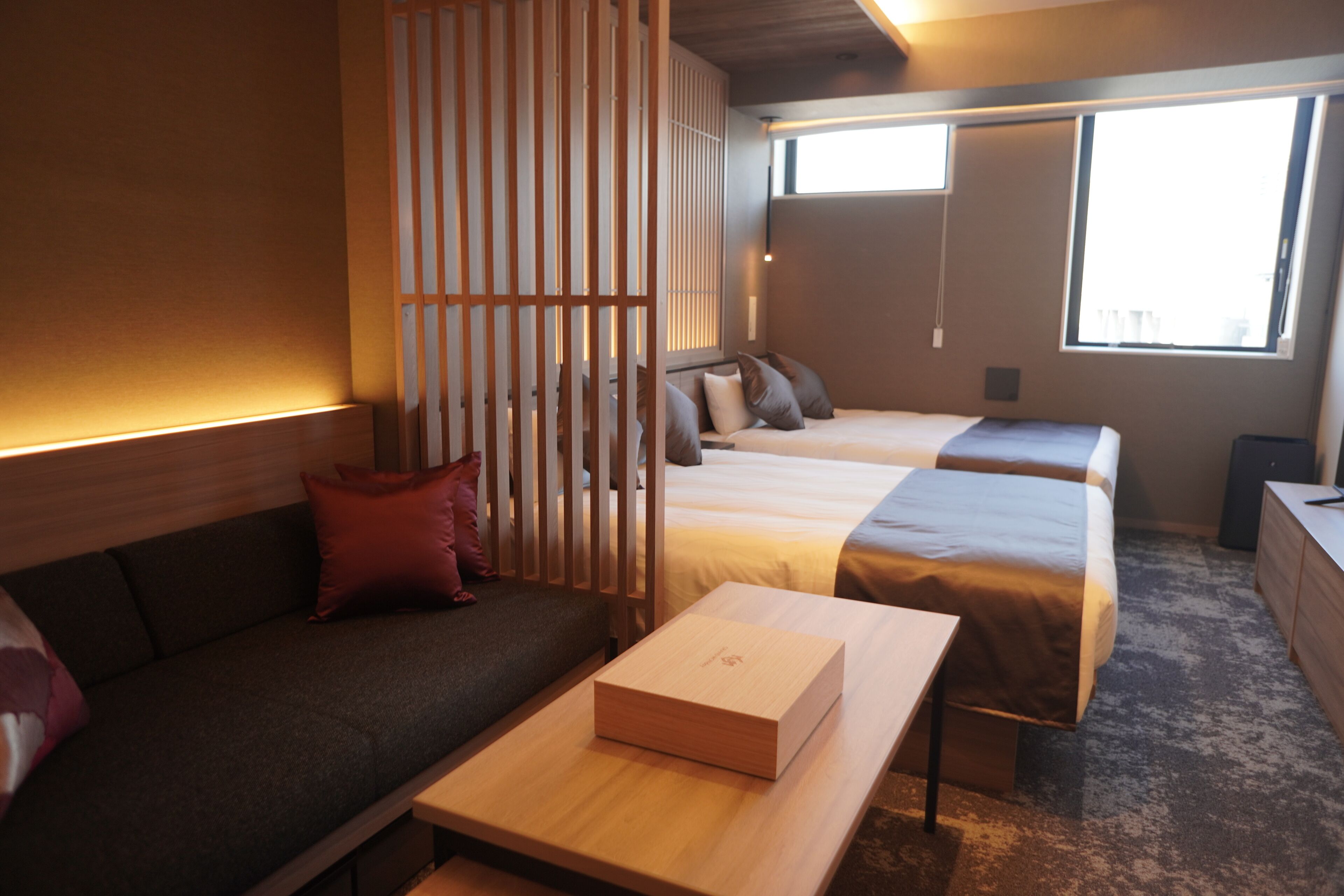 Ein Hotelzimmer mit Bett, einer Couch, einem Tisch und einer Raumtrennung.