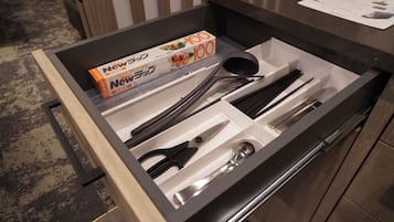 A drawer with neatly organized kitchen utensils, including scissors, a spoon, and a spatula.