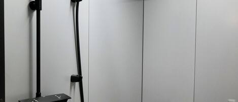 A modern bathroom with a black bathtub, a handheld showerhead, and a white sink.