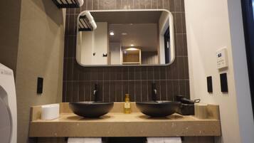 Un baño con dos lavamanos, un espejo y un perchero para toallas.