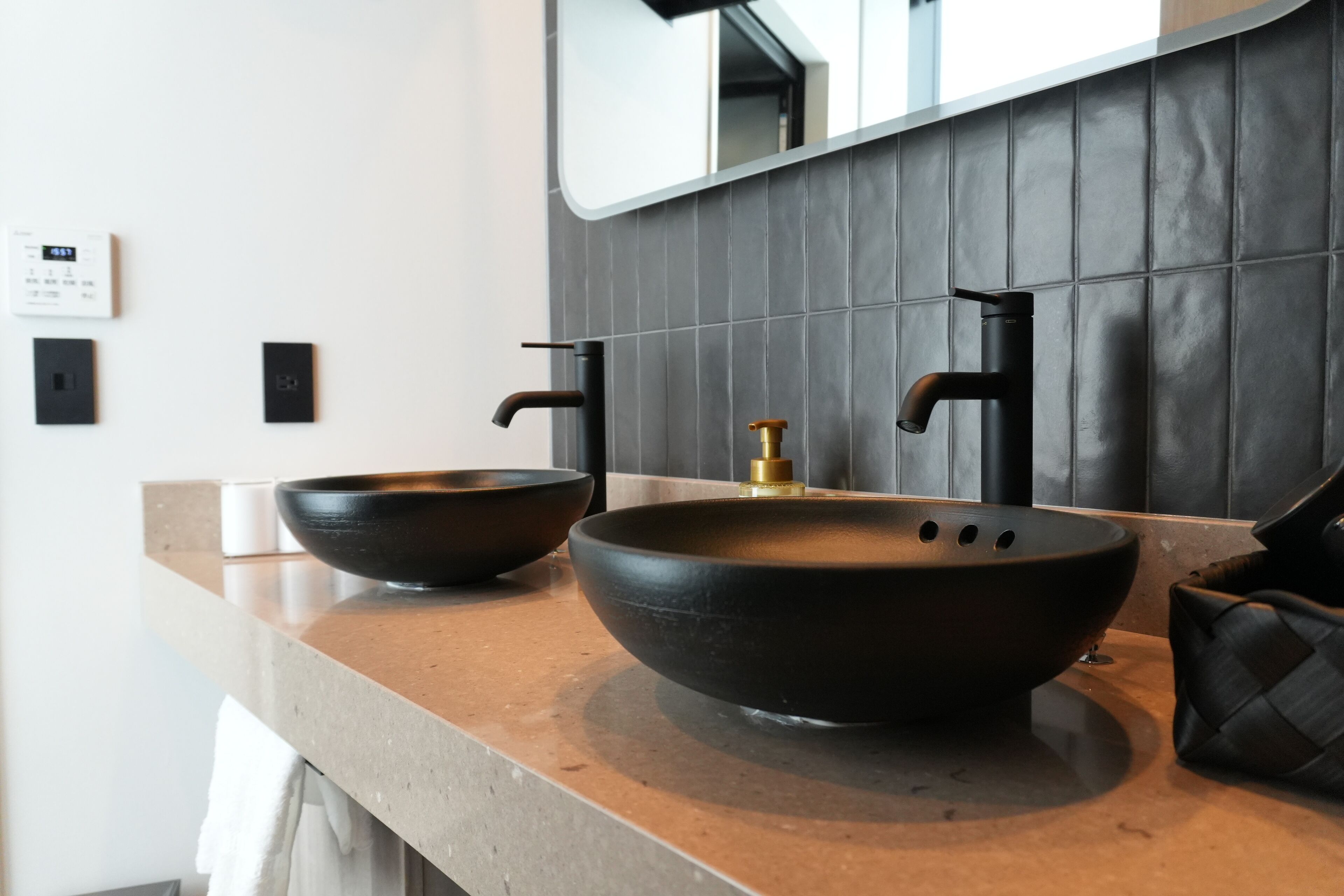 Une salle de bain moderne avec un grand lavabo rond posé sur un meuble et un miroir au-dessus.