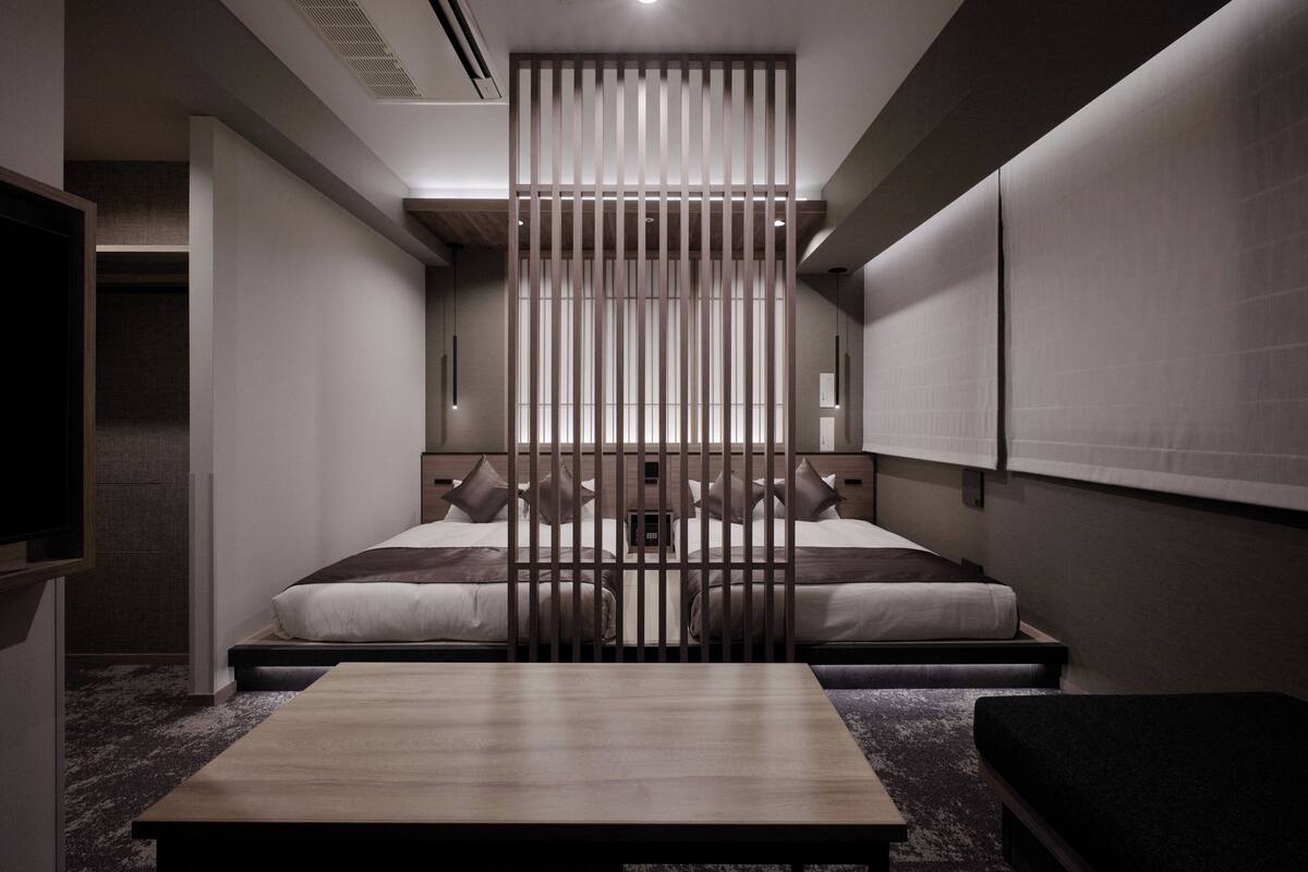 Una habitación de hotel moderna con cama, escritorio y un separador.