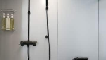 A modern bathroom with a black bathtub, a white toilet, and a shower with a handheld showerhead.