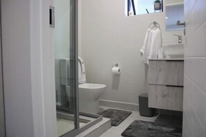 Een douche, handdoeken, zeep, toiletpapier