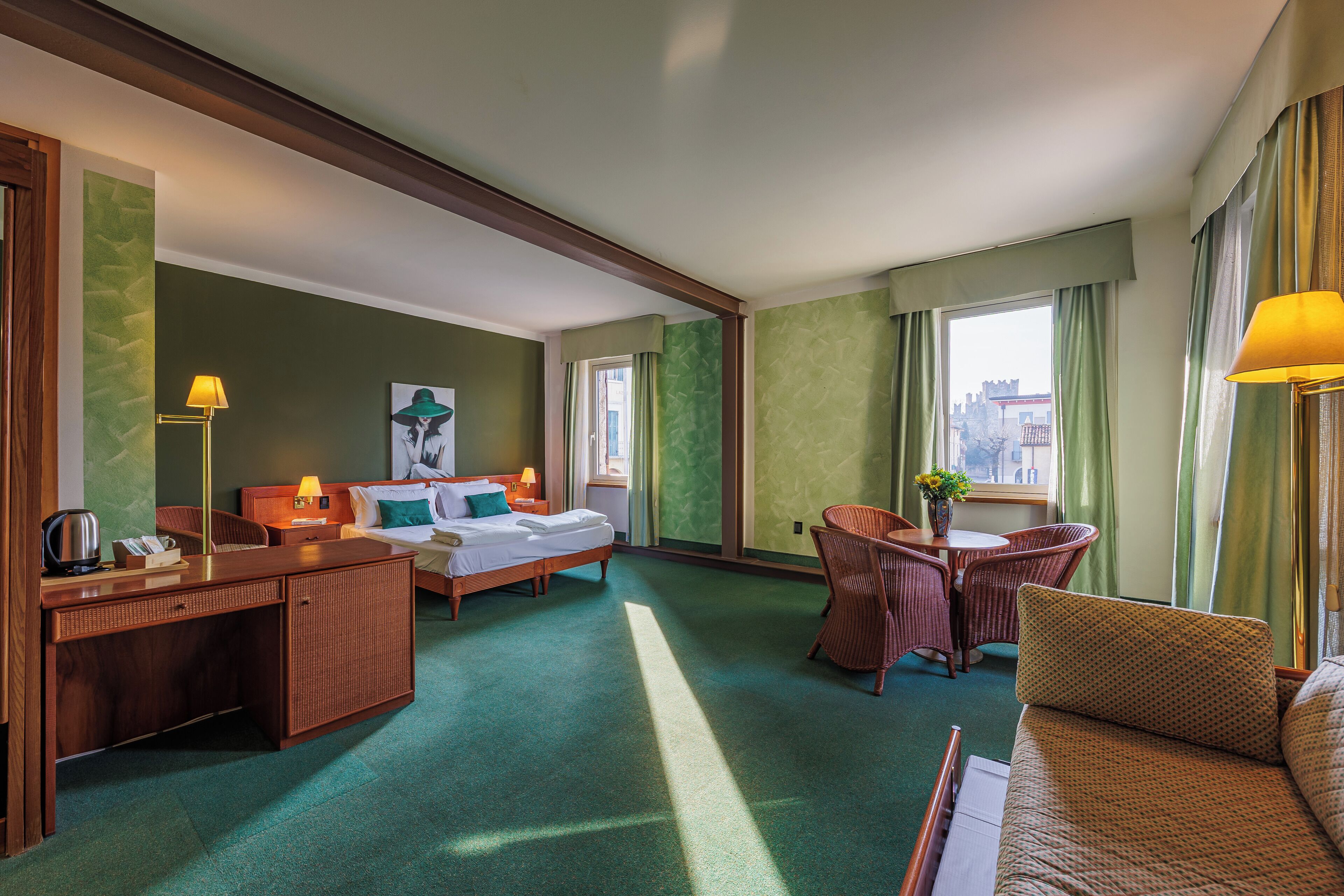 Una habitación de hotel con cama, escritorio, silla y sofá.
