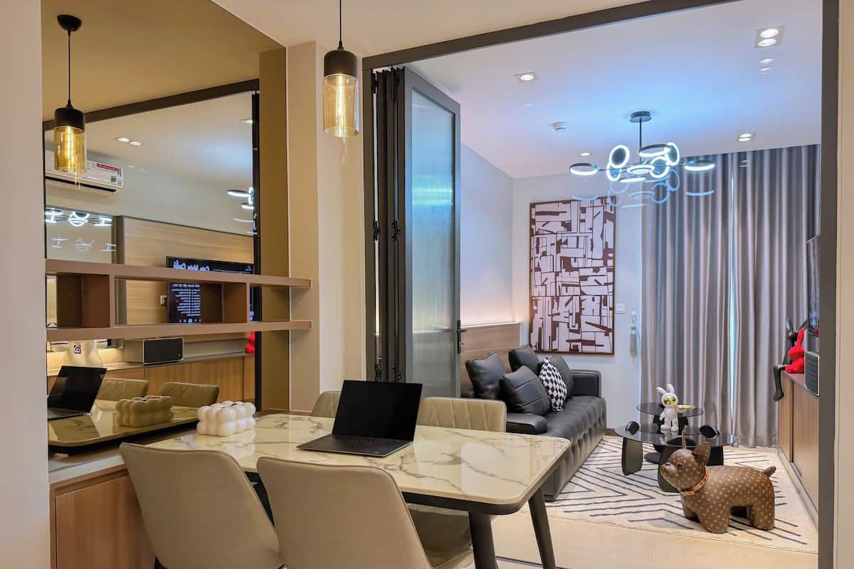 A modern living room with a sofa, a coffee table, and a laptop on the table.