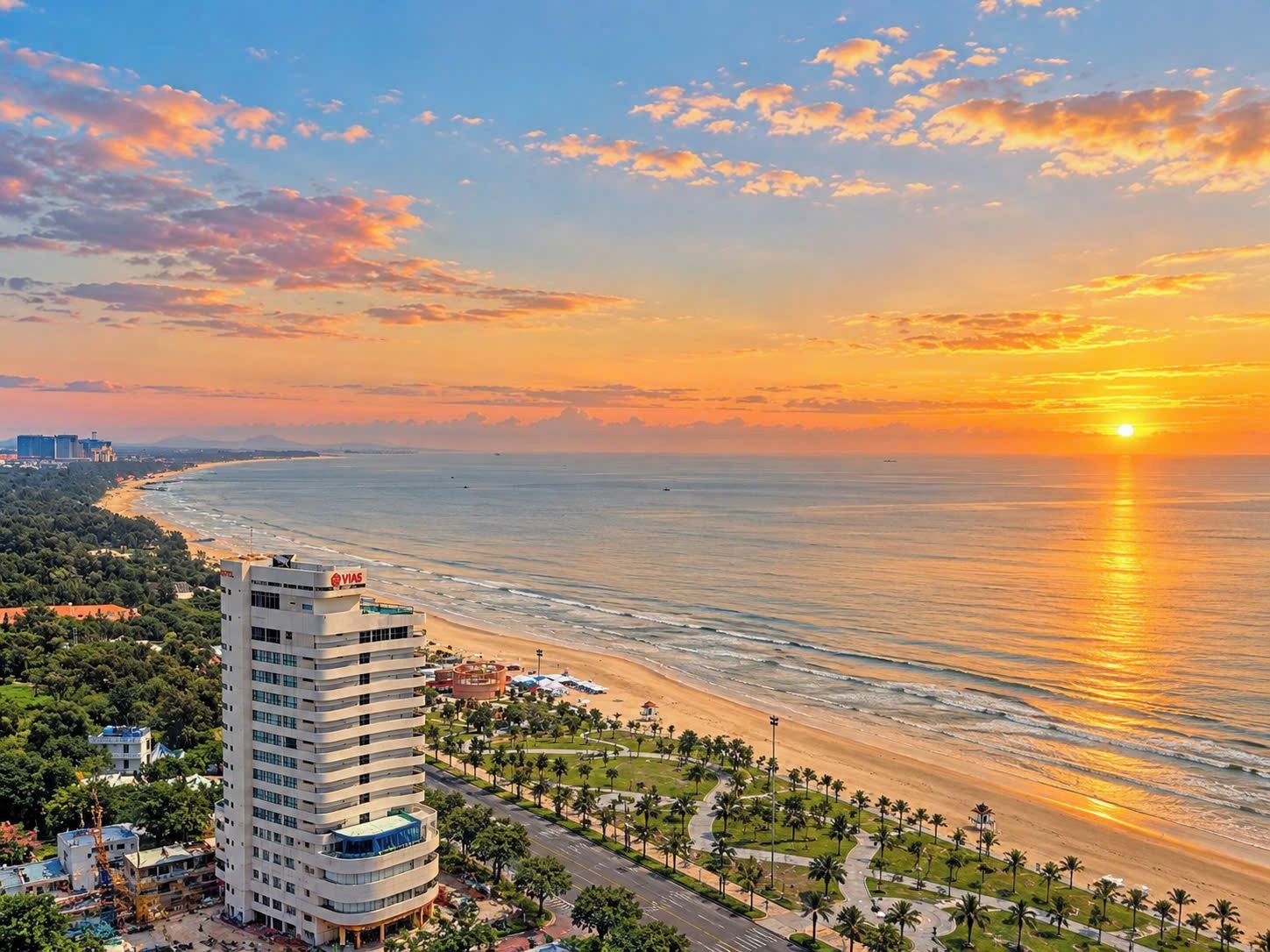 Un paysage urbain côtier avec un hôtel imposant, une plage et un coucher de soleil.