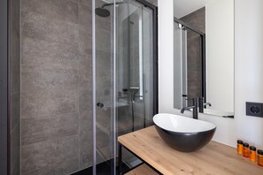 A modern bathroom with a glass-enclosed shower, a wooden vanity with a large vessel sink, and a mirror above the sink. - House by Lake Sint-Annaland near Marina (Sint-Annaland)