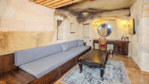 Ein gemütliches Zimmer mit einer hölzernen Sitzbank, einem Esstisch und einem Spiegel über dem Waschbecken.