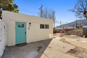 Un petit bâtiment d’un seul étage, avec une porte de couleur turquoise et le chiffre « 3 » peint sur le mur.