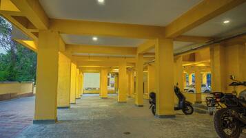 A covered parking area with yellow pillars and a tiled floor.
