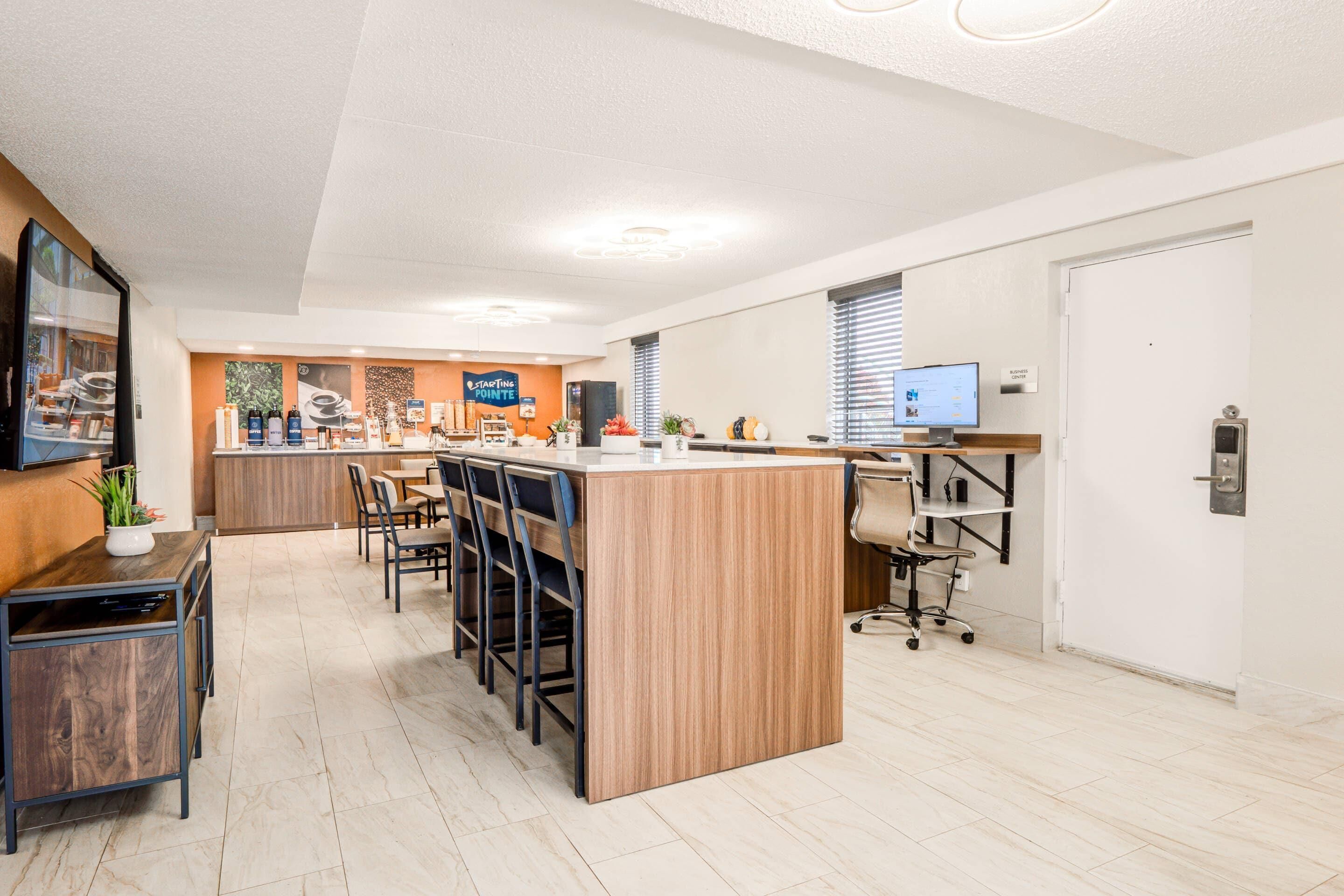 Un moderno vestíbulo de hotel con mostrador de recepción, zona de bar y asientos.