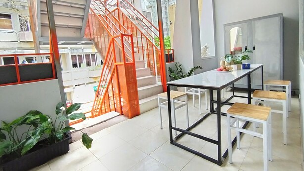 A modern interior with a staircase, a dining area, and large windows. - Anh's House Modern Homestay 2 (Ho Chi Minh City)