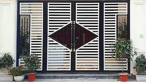 A black and white gate with a diamond-shaped central panel and two symmetrical wings. - Anh's House Modern Homestay 2 (Ho Chi Minh City)