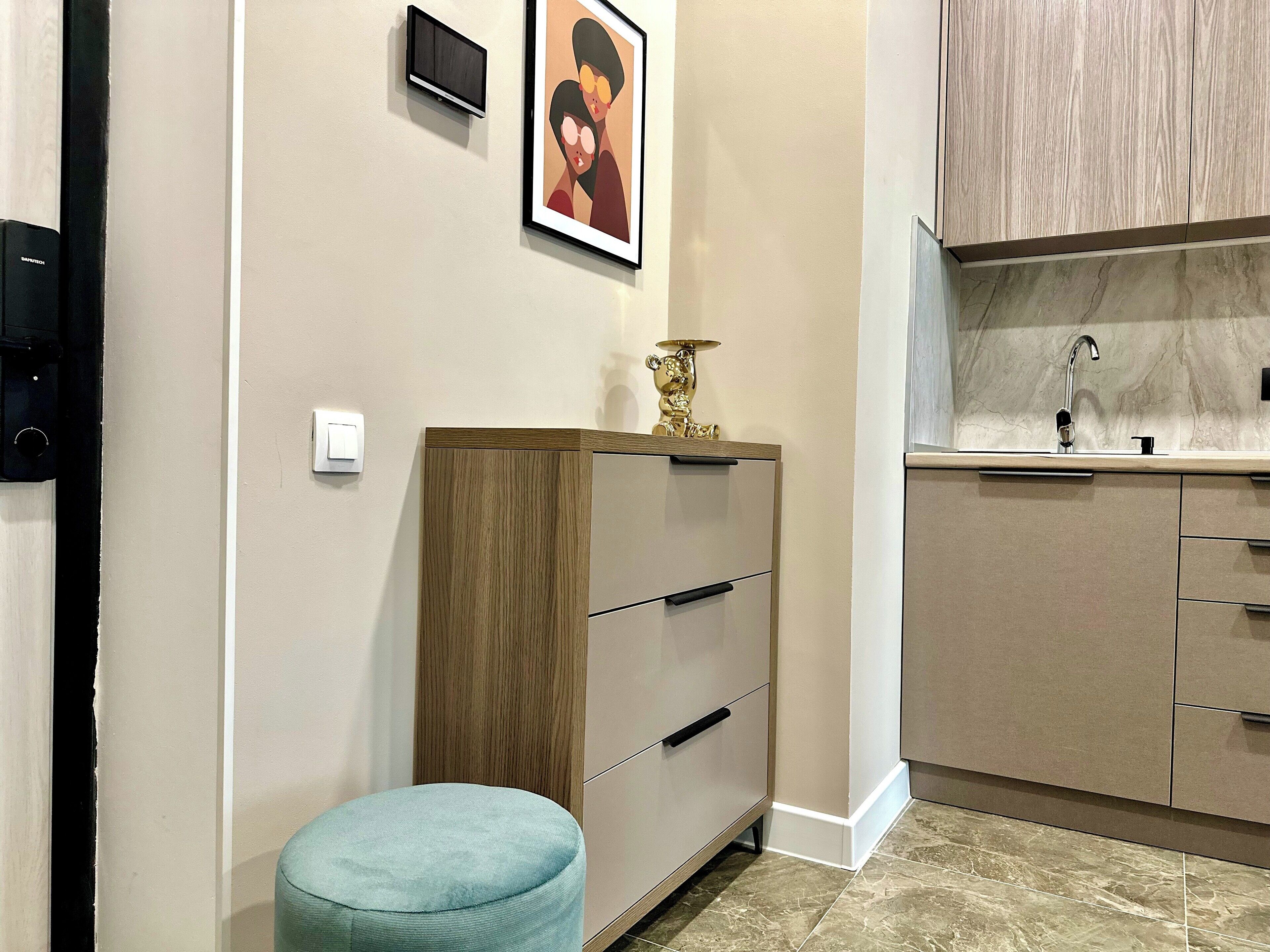 A modern kitchen with wooden cabinets, a marble countertop, and a sink.