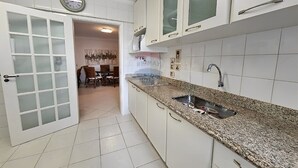 A kitchen with white cabinets, a granite countertop, and a stainless steel sink.