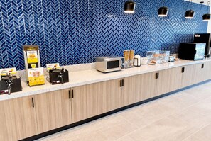 A modern kitchen counter with waffle makers, a microwave, and a coffee machine. - Hawthorn Extended Stay by Wyndham Mebane (Mebane)