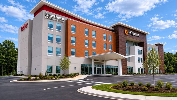 Un hotel moderno con techo plano, varias ventanas y entrada cubierta.