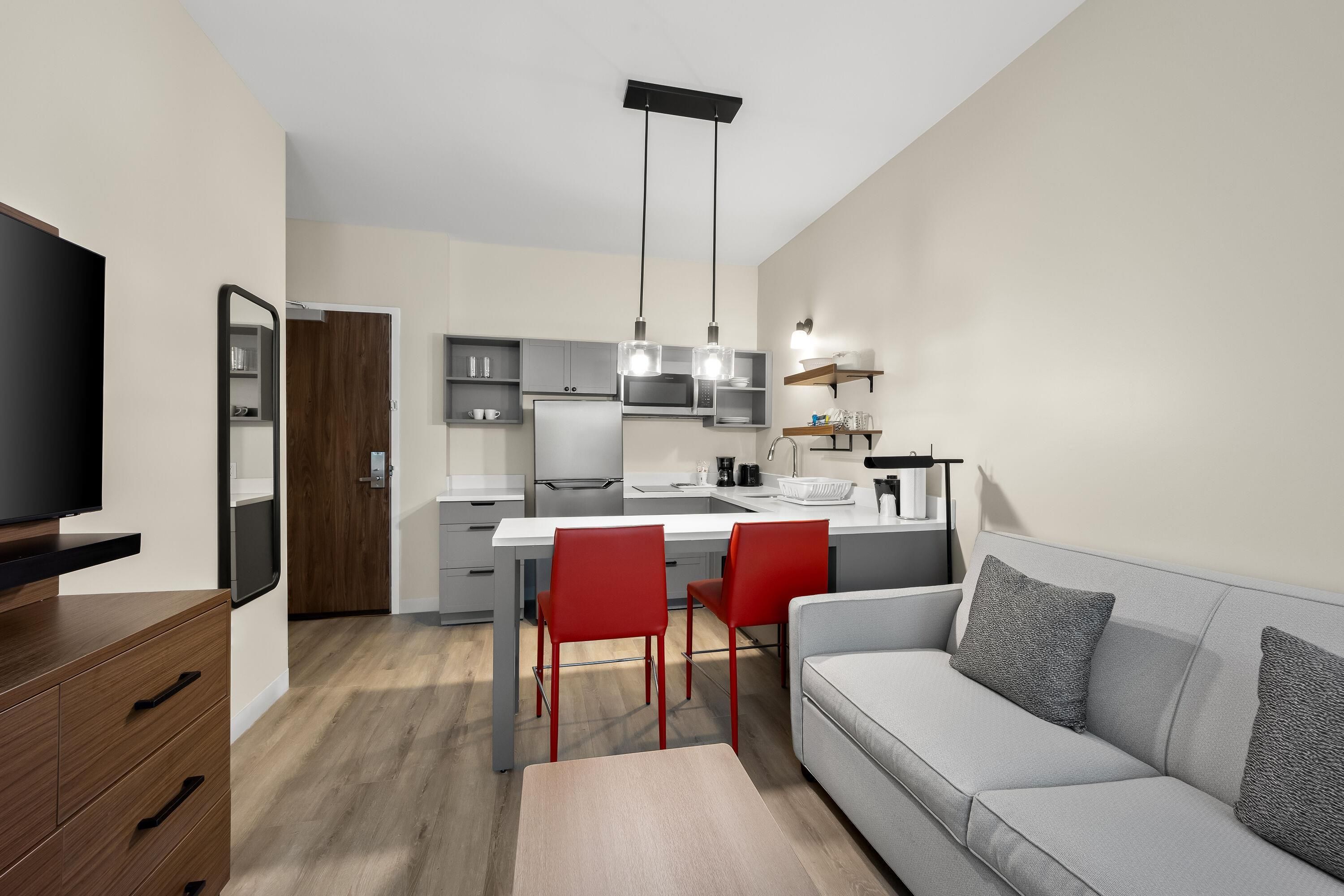 A modern apartment with a dining area, kitchen, and living room.