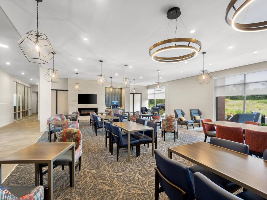 A modern dining area with hexagonal pendant lights, a fireplace, and a view of the outdoors.