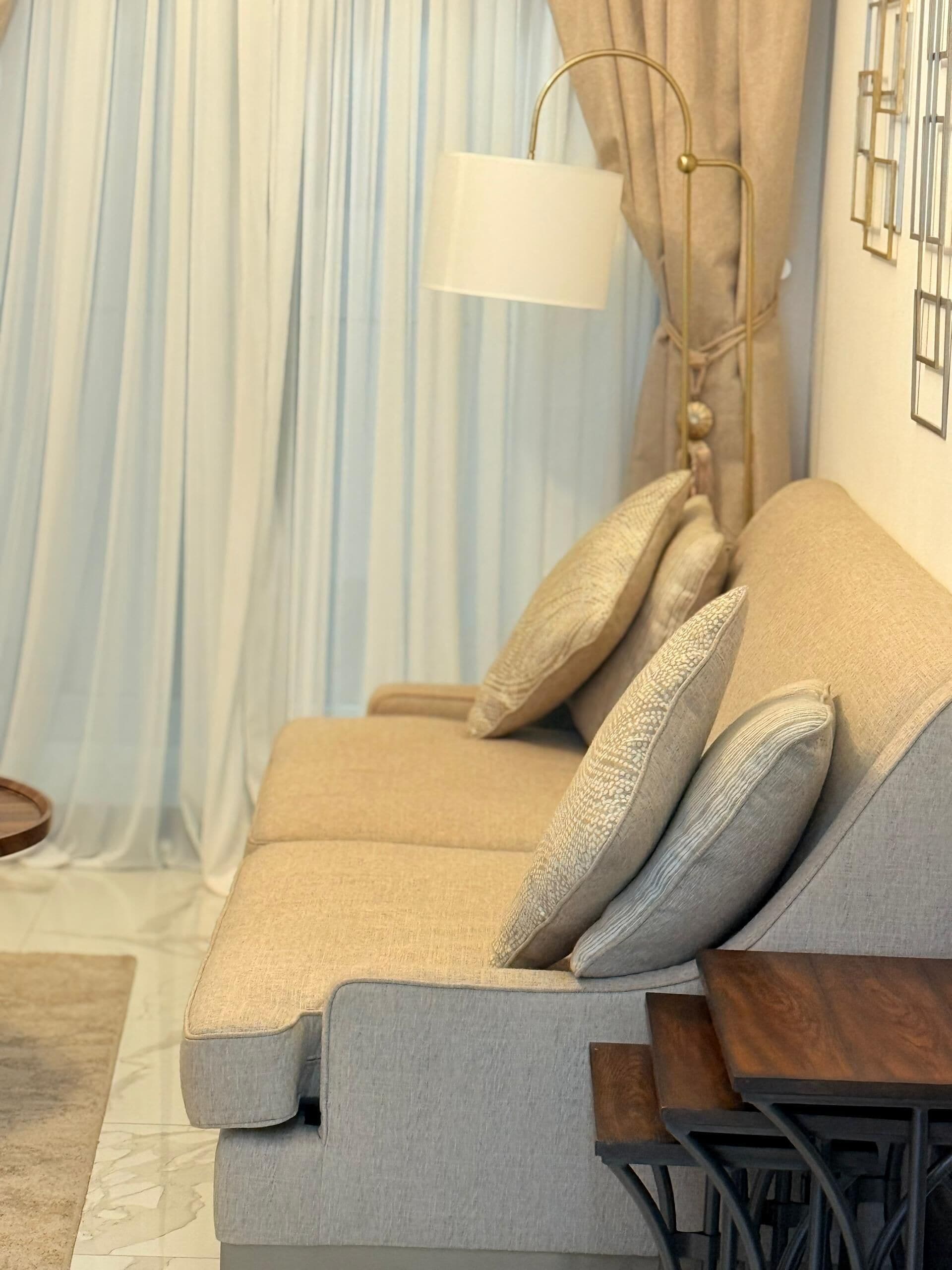 A modern living room with a sofa, a side table, and a lamp.