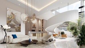 A modern living room with a curved glass wall, a white sofa, a coffee table, and a large abstract painting. - Quao Realty - The Essence (Accra)