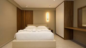 A modern hotel room with a large bed, a bedside table, a wall-mounted light, and a wooden panel on the wall.
