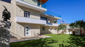 A modern two-story building with a balcony, a statue, and a well-maintained lawn. - Apartments Luxury Mimani 2 (Velabisht)