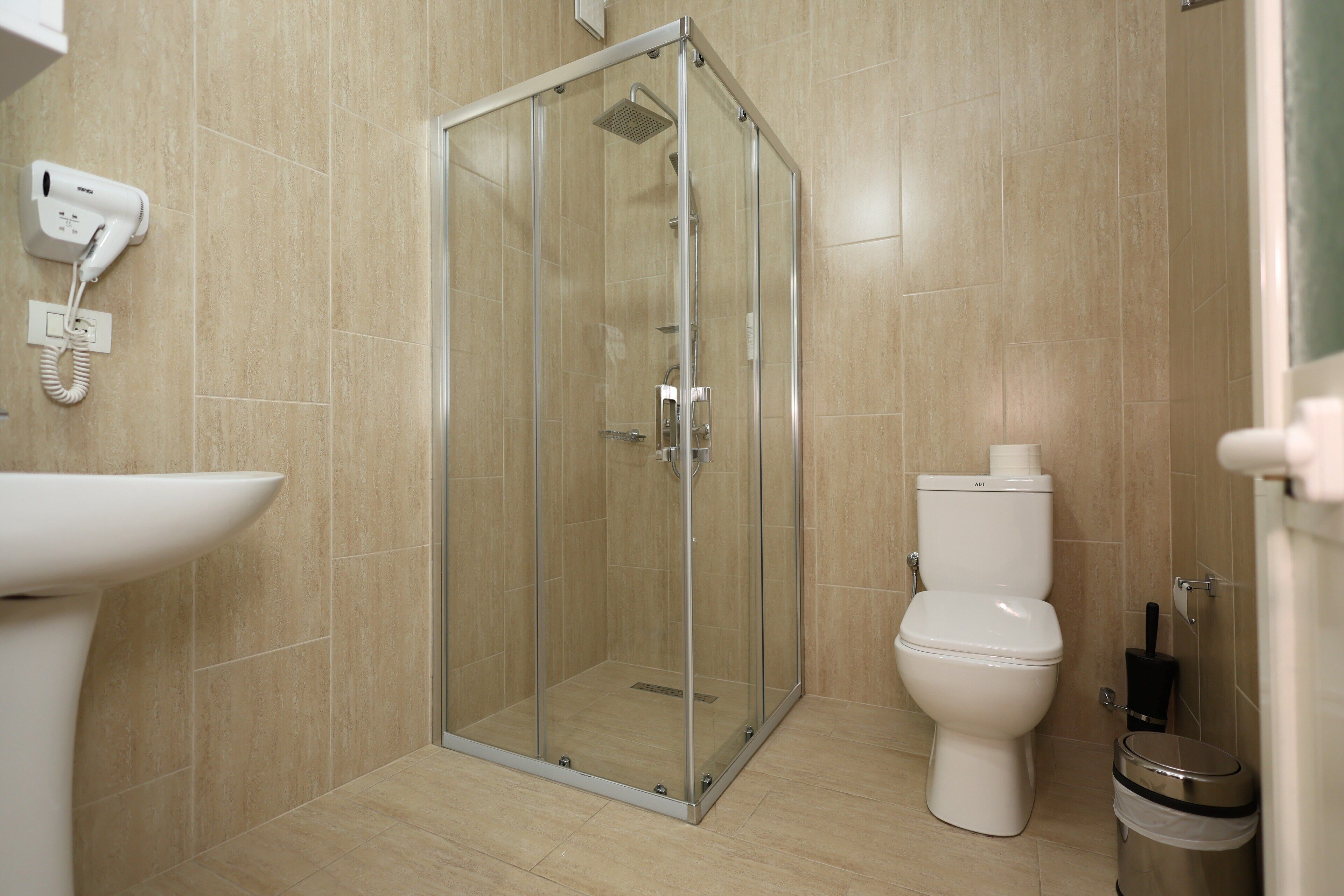 Ein modernes Badezimmer mit einer Duschkabine, einer Toilette und einem Waschbecken.