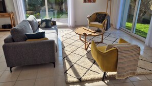 Un salon moderne avec un canapé, un fauteuil et une table basse.