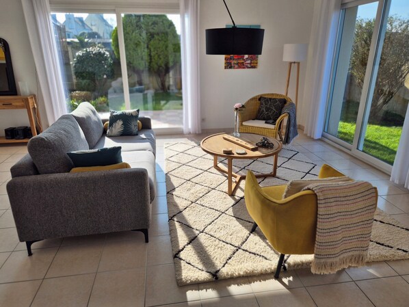 A modern living room with a sofa, armchair, and coffee table. - New single-story house, 1.2 km from the beach, sleeps up to 4 people (Plouguerneau)
