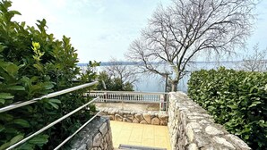 Una escalera de piedra que conduce a una terraza con vistas a un cuerpo de agua.