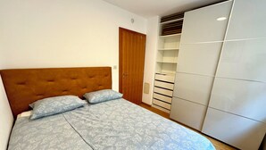 Un dormitorio con cama, armario y puerta.