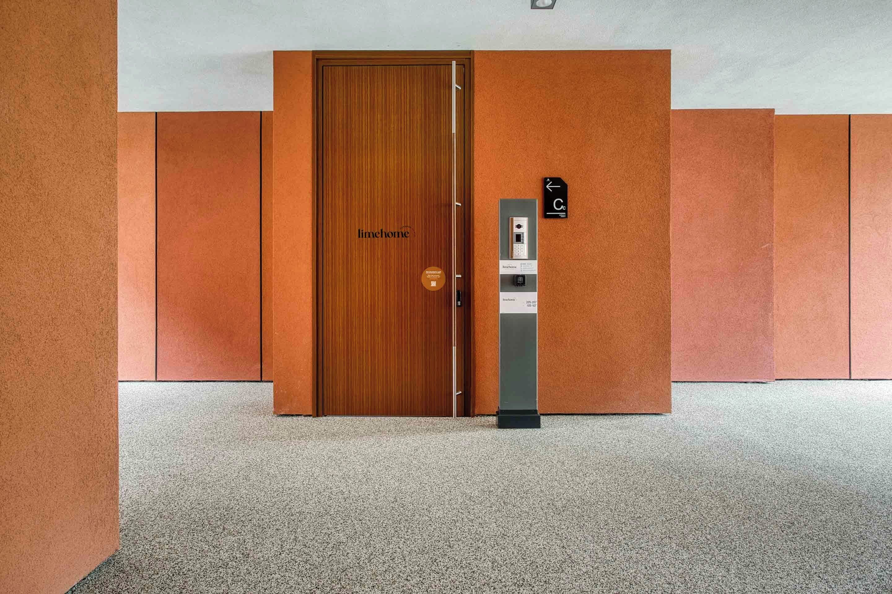 A wooden door labeled "limemhome" with a keypad lock and a control panel to the right.