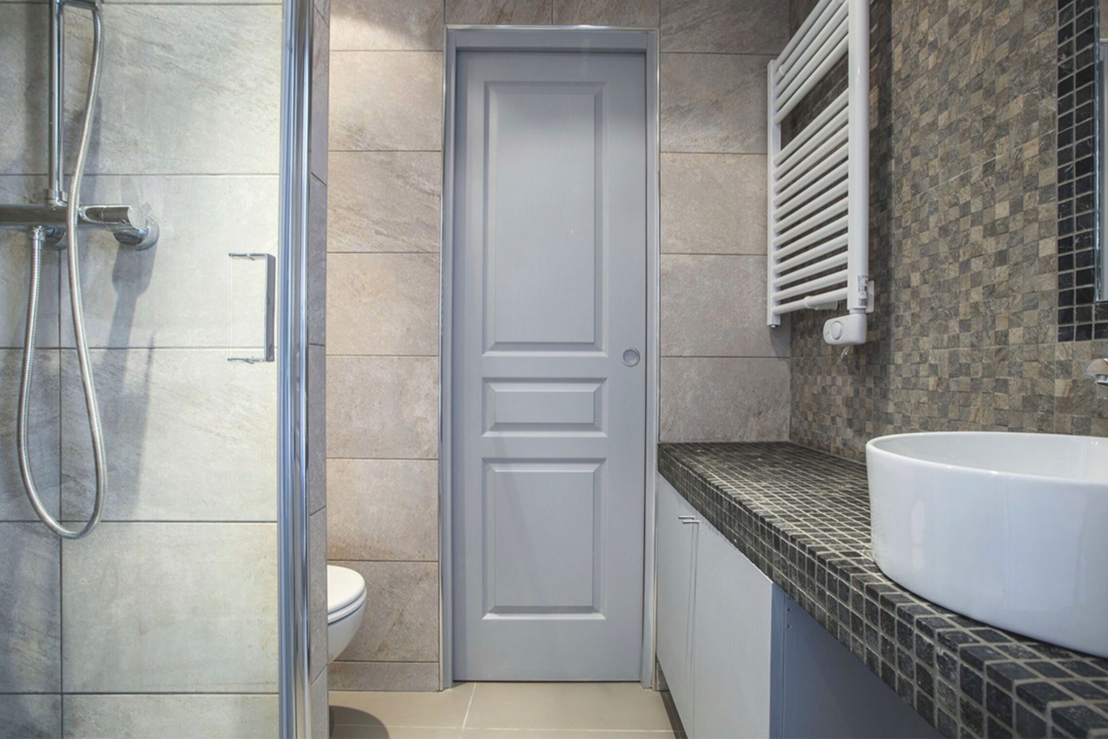 A bathroom with a shower, toilet, and sink.