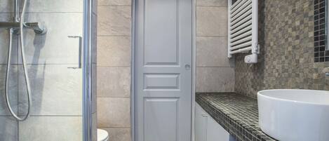 A bathroom with a shower, toilet, and sink.