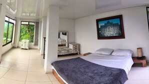 Un dormitorio con una cama grande, un aparador, un espejo y un cuadro en la pared.