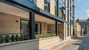 A modern building with large windows, a stone-paved courtyard, and a clear blue sky. - Forth House by Supercity Aparthotels (Edinburgh)