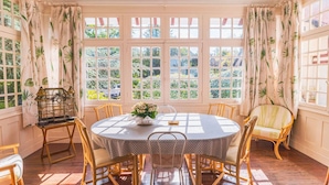 A dining area with a round table, chairs, and a birdcage.