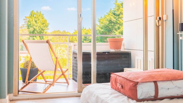 Ein Schlafzimmer mit einer großen Schiebeglasdoor zu einem Balkon.