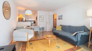Ein modernes Wohnzimmer mit Sofa, Couchtisch und Essbereich.
