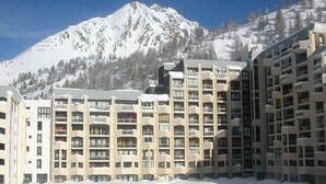 A snow-covered mountain with a hotel complex in the foreground. - Cozy studio at the foot of the slopes with terrace (Isola 2000)